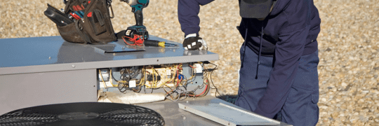 technician doing maintenance on a HVAC unit